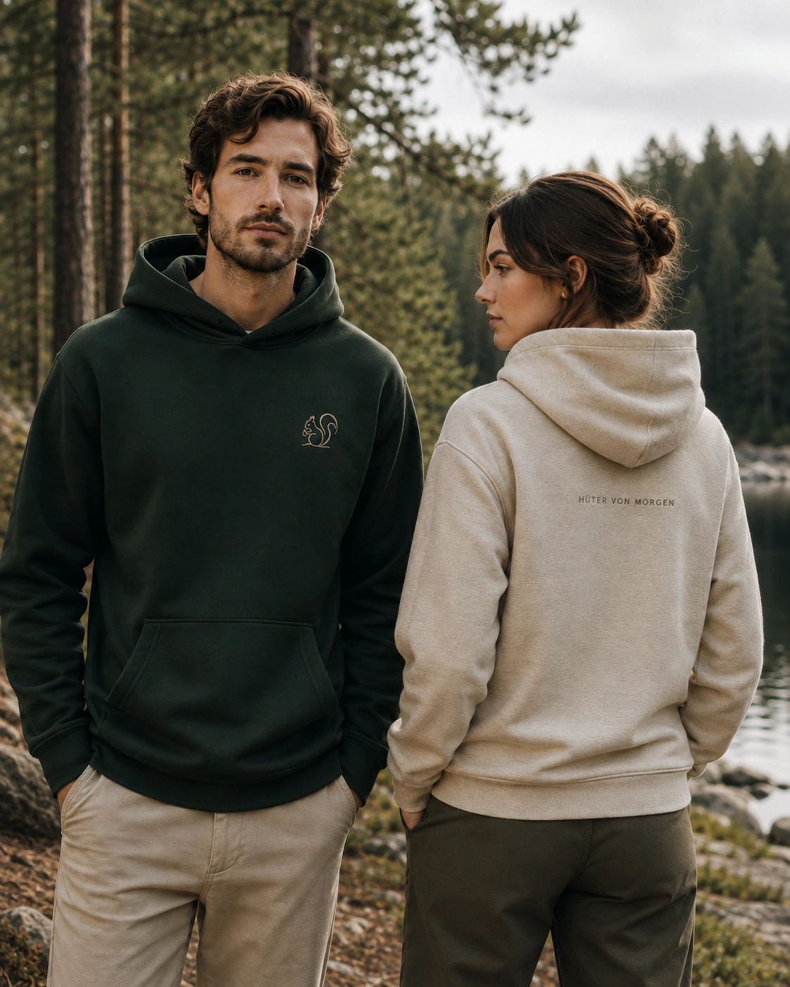 Eekättken-Hoodies in der Natur: Mann mit Eichhörnchen-Brustlogo und Frau mit dem Rückenclaim HÜTER VON MORGEN.